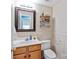 Half bathroom with decorative mirror, tiled wall and shelving, and an adjacent sink at 1013 Nez Perce Ln, Monroe, NC 28110