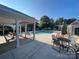 A community pool surrounded by lounge chairs and tables under a blue sky at 10135 Blakeney Preserve Dr, Charlotte, NC 28277