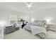 Comfortable main bedroom with a plush bed, gray chair, and bright windows at 10135 Blakeney Preserve Dr, Charlotte, NC 28277