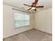Bedroom with neutral carpet features a window and ceiling fan; perfect for relaxation at 1016 Yellow Daisy Dr, Matthews, NC 28104