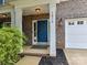 Inviting front entrance featuring a blue door, brick facade, and manicured landscaping at 1016 Yellow Daisy Dr, Matthews, NC 28104
