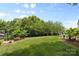 Large backyard featuring a lush lawn, mature trees, and an inviting bench at 10621 Glenmac Rd, Charlotte, NC 28215