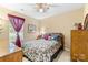 Cozy bedroom with floral bedding, a ceiling fan, and natural light at 10621 Glenmac Rd, Charlotte, NC 28215