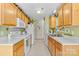 Galley kitchen features wooden cabinetry, white countertops, and appliances at 10621 Glenmac Rd, Charlotte, NC 28215