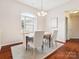 Dining room with neutral paint and decor, hardwood flooring, large window and modern chandelier at 116 Birchwood Ct, Mount Holly, NC 28120