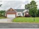 Charming home featuring a brick and vinyl exterior, attached garage and a well-manicured front lawn at 116 Birchwood Ct, Mount Holly, NC 28120