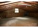 A well lit attic space with exposed beams and plywood floors and walls at 1270 N Enochville Ave, China Grove, NC 28023