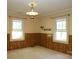 Classic bedroom featuring wood-paneled walls and natural light from two windows at 1270 N Enochville Ave, China Grove, NC 28023