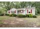 Inviting home with red shutters and a welcoming porch, surrounded by mature landscaping and trees at 1270 N Enochville Ave, China Grove, NC 28023