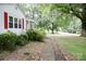 Charming home featuring a brick pathway leading to the entrance, accented by manicured shrubs and trees at 1270 N Enochville Ave, China Grove, NC 28023