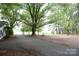 Scenic view of a property with mature trees and a glimpse of a waterfront area beyond the driveway at 1270 N Enochville Ave, China Grove, NC 28023