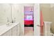 Bathroom view into bedroom featuring a sink with vanity and a glimpse of pink bedding at 14018 Drake Watch Ln, Charlotte, NC 28262