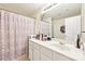 Bathroom features a large mirror, white vanity, and shower with patterned curtain at 14018 Drake Watch Ln, Charlotte, NC 28262