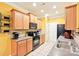 Bright eat-in kitchen has wood cabinets, black appliances, and a tile backsplash at 14018 Drake Watch Ln, Charlotte, NC 28262