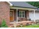 Close up of welcoming front porch with chairs and potted plants on charming brick home at 1483 Dawnview Ln, Lincolnton, NC 28092