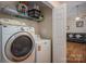 Laundry room with washer, dryer, and shelving that leads into an open-concept living space at 1483 Dawnview Ln, Lincolnton, NC 28092