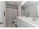 Bright bathroom featuring a double sink vanity and a shower with a decorative floral curtain at 151 Outrigger Ln, Troutman, NC 28166