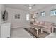 Bedroom featuring a ceiling fan, two windows, a striped couch, and neutral carpet at 151 Outrigger Ln, Troutman, NC 28166