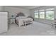 Bright bedroom featuring carpeted floors, large windows, and a beautiful upholstered headboard at 151 Outrigger Ln, Troutman, NC 28166