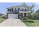 Beautiful two-story home featuring a two-car garage, and a well-manicured lawn at 151 Outrigger Ln, Troutman, NC 28166