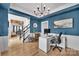 Bright blue office with a large desk, bookshelves, and modern decor with view to staircase at 15737 Agincourt Dr, Huntersville, NC 28078