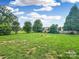 Expansive backyard features a well-manicured lawn, mature trees, and a charming bird bath at 1625 Damascus Cir, Conover, NC 28613