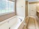 Bathroom featuring a soaking tub with tiled floors and natural light from the window at 1625 Damascus Cir, Conover, NC 28613
