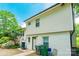 Exterior view of the home with a paved area, lush greenery, and rear entrance at 1645 Brookdale Ave, Charlotte, NC 28210