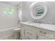 Bright bathroom with marble vanity, round mirror, white subway tile, and stylish patterned tile flooring at 1645 Brookdale Ave, Charlotte, NC 28210
