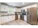 Modern kitchen with white cabinets, stainless steel appliances, and stylish backsplash at 1645 Brookdale Ave, Charlotte, NC 28210