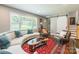 Comfortable living room with large windows, a modern sofa, and a unique sliding barn door feature at 1645 Brookdale Ave, Charlotte, NC 28210