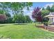 Large backyard with a deck, lots of green grass, and mature trees providing shade at 166 Rumple Hill Dr, Statesville, NC 28677