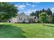 Well-kept home with an attached garage, surrounded by a spacious, green lawn and mature trees at 166 Rumple Hill Dr, Statesville, NC 28677