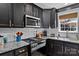 Well-lit kitchen featuring black cabinetry, granite countertops, stainless steel appliances, and subway tile backsplash at 166 Rumple Hill Dr, Statesville, NC 28677