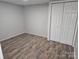 Basement bedroom with wood-look flooring, closet, and neutral paint at 1660 Songwood Rd, Concord, NC 28025