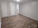 Finished basement bedroom with laminate flooring, closet doors, and neutral paint at 1660 Songwood Rd, Concord, NC 28025