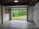 Basement garage with open overhead door and view to a lush green backyard at 1660 Songwood Rd, Concord, NC 28025