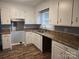 Well-lit kitchen features white cabinets, granite countertops, and stainless steel appliances at 1660 Songwood Rd, Concord, NC 28025