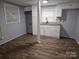 Finished basement kitchenette with white cabinets, granite countertop, sink, and wood-look floors at 1660 Songwood Rd, Concord, NC 28025