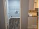 View of the laundry room with wooden floors and access to the kitchen, with laundry hookups and shelving at 1660 Songwood Rd, Concord, NC 28025