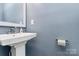 Modern bathroom with a pedestal sink, stylish mirror, and contemporary finishes at 1723 Town Oak Ln, Charlotte, NC 28205