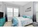 Bright bedroom featuring a large window, grey walls, and comfortable bedding at 1723 Town Oak Ln, Charlotte, NC 28205
