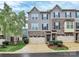 Charming townhome with stone accents, gray siding, attached garages and manicured landscaping at 1723 Town Oak Ln, Charlotte, NC 28205