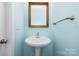 Cozy half bathroom with blue wall, pedestal sink and silver hardware at 181 Singleton Rd, Mooresville, NC 28117
