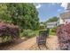 Inviting backyard with a brick patio and relaxing rocking chairs with mature landscaping at 188 Lilac Mist Loop, Mooresville, NC 28115