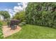 Relaxing backyard featuring a brick patio, lush green lawn, and mature trees for privacy at 188 Lilac Mist Loop, Mooresville, NC 28115