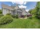 The backyard features a lush green lawn, manicured shrubs, a rock patio, and a screened porch at 188 Lilac Mist Loop, Mooresville, NC 28115