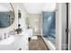 Bright bathroom with double vanity, stylish mirrors, and a large glass-enclosed shower with blue tile at 188 Lilac Mist Loop, Mooresville, NC 28115