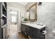 Bathroom features a black vanity with marble countertop, and decorative mirror at 188 Lilac Mist Loop, Mooresville, NC 28115