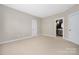 This is a bright, carpeted bedroom with neutral walls and trim and an open door to the primary bathroom at 188 Lilac Mist Loop, Mooresville, NC 28115